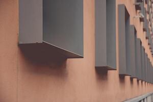Geometric urban structure of pale brown wall and rows of metal framed windows in dimensional perspective. Modern architecture of Berlin Germany. Details of building exterior photo