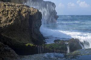 Splashing waves hitting the rocks and cliffs on the beach. a beautiful beach in Tulungagung, East Java, Indonesia. photo