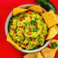 Guacamole served with tortilla chips in a bowl photo