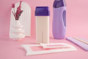 Aesthetic Waxing Kit featuring Applicator and Strips set on a Pink Background photo