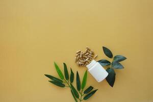 Natural Dietary Supplements Featuring Green Leaves Set on a Yellow Background photo
