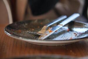 An empty dirty plate with a fork. photo