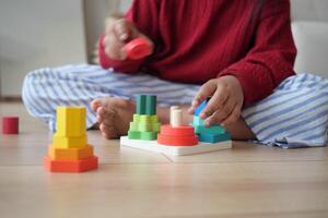 A Child Enjoys Playing with Vibrant and Colorful Stacking Toys on a Wooden Floor photo