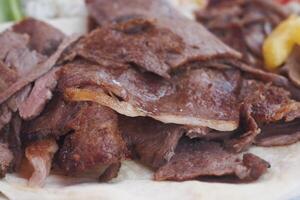 Enjoying Delicious Slices of Juicy Grilled Meat Served on Tortilla photo
