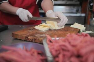 A chef skillfully slices butter and meat in an organized kitchen photo