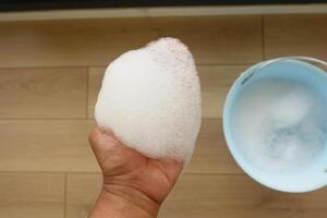 A small amount of soapy foam was collected in a bucket for household cleaning and hygiene photo