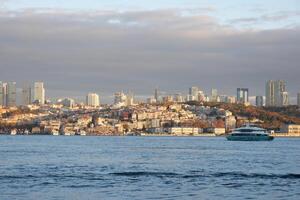 Istanbul Skyline at Sunset with a ferry gliding on the water photo