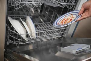 Loading Plates into a Dishwasher for Thorough and Efficient Cleaning Process photo