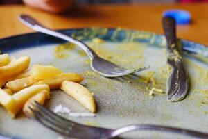 An empty plate with a spoon rests after a delicious, satisfying meal has been enjoyed photo