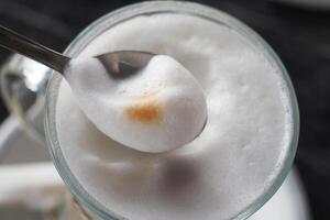 Rich and Creamy Foam on Coffee Served with a Spoon for Enjoyment photo