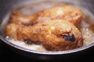 Delicious and Crispy Fried Chicken Drumsticks Cooked in a Pan photo