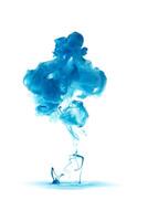 Blue ink dropped in to water isolated white background. Abstract color dissolving in water photo