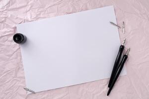 Paper with two dip pen on wrinkled paper texture background. photo