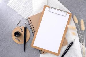 Clipboard with dip pen on stone texture background. photo