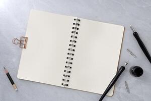 Blank book and dip pen on stone texture background. photo