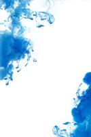 Blue ink dropped in to water isolated white background. Abstract color dissolving in water photo