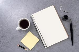 Book with dip pen and coffee on stone texture background. photo