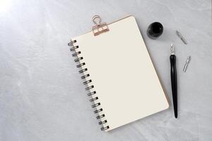 Book with dip pen on stone texture background. photo