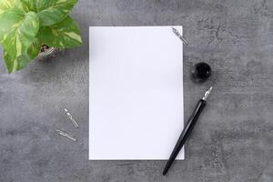 Blank paper with dip pen on stone texture background. photo