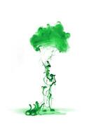 Green ink dropped in to water isolated white background. Abstract color dissolving in water photo