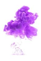 Purple ink dropped in to water isolated white background. Abstract color dissolving in water photo