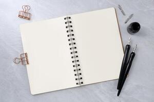 Blank book with two dip pen on stone texture background. photo