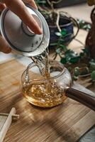 Pouring aromatic tea into a beautiful teapot surrounded by greenery, enhancing elegance photo