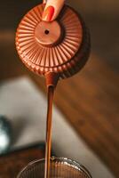 An Elegant Coffee is Being Poured Gracefully from a Beautifully Designed Teapot with Style photo
