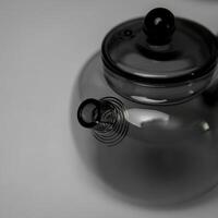 A Stylish and Modern Glass Teapot that Features a Unique and Intriguing Spout Design photo