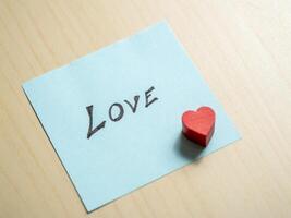 Love note on blue paper with red heart intimate setting emotional concept close-up view photo
