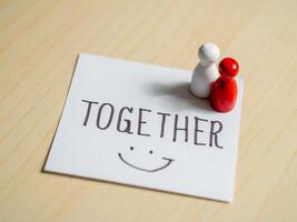 Togetherness message with figurines on paper office space inspirational concept close-up view photo