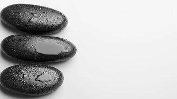 Black spa stones arranged in a minimalist line on a soft white background photo