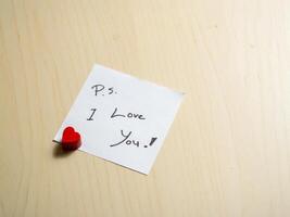 Close-up of a romantic love note with heart charm in an affectionate home setting photo