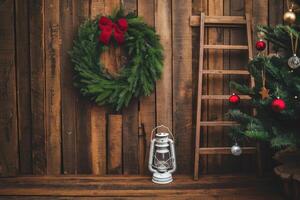 Christmas wreath, lantern and tree creating festive atmosphere on rustic wooden wall photo