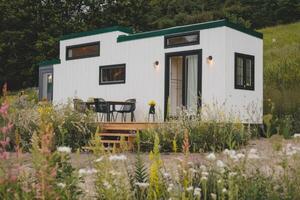 Tiny house nestled in a meadow of wildflowers embracing sustainable living photo