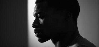 A black man is silhouetted against a light photo