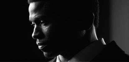 A black man in a suit and tie looking away photo
