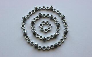 Mechanical Circle Pattern Of Metallic Color Nuts And Injected Bolts Isolated On Plastic Surface Top View photo