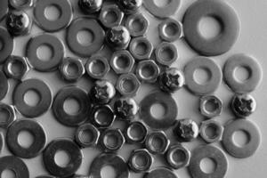 Monochrome Photo Of Variety Fasteners And Hardware Items In Flat Layer On White Workbench. Fasteners And Hardware Products Royalty Free Image