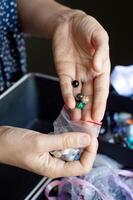 Hand Picking Beads from a Selection for Craft Project photo