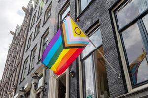 Progress Pride flag displayed on the exterior of a historic building photo
