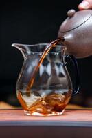 Experience the captivating and elegant tea pouring ritual conducted with a beautiful glass pitcher photo
