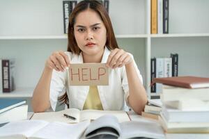 Asian student woman have anxiety because of exams, female prepare for test and learning lessons in the library. stress, despair, haste, misunderstanding reading, discouraged, expectation, knowledge photo
