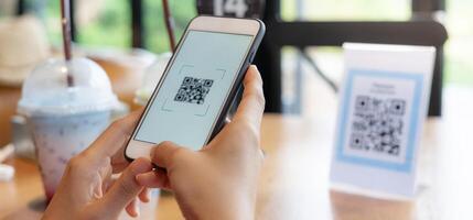 Woman use smartphone to scan QR code for order menu in cafe restaurant with a digital delivery. Choose menu and order accumulate discount. E wallet, technology, pay online, credit card, bank app. photo