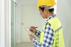 inspector or engineer is inspecting construction and quality assurance new house using a checklist. Engineers or architects or contactor work to build the house before handing it over to the homeowner photo