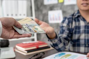 Businessmen receive salary or bonuses from management or Boss. Company give rewards to encourage work. Smiling businessman enjoying a reward at the desk in the office. photo