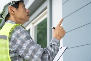 inspector or engineer is inspecting construction and quality assurance new house using a checklist. Engineers or architects or contactor work to build the house before handing it over to the homeowner photo