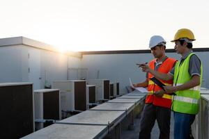 Engineers use blueprint check air condition systems on site. Contractor and inspector inspection compressor during project. maintenance team check quality assurance. Audit, inspect, quality control. photo