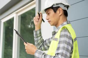 inspector or engineer is inspecting construction and quality assurance new house using a checklist. Engineers or architects or contactor work to build the house before handing it over to the homeowner photo