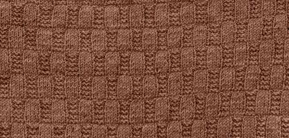 Texture of smooth knitted sweater with pattern. Handmade knitting wool or cotton fabric texture. Background of Large knit pattern with knitting needles or crochet. Mocha Mousse colour of 2025 year photo
